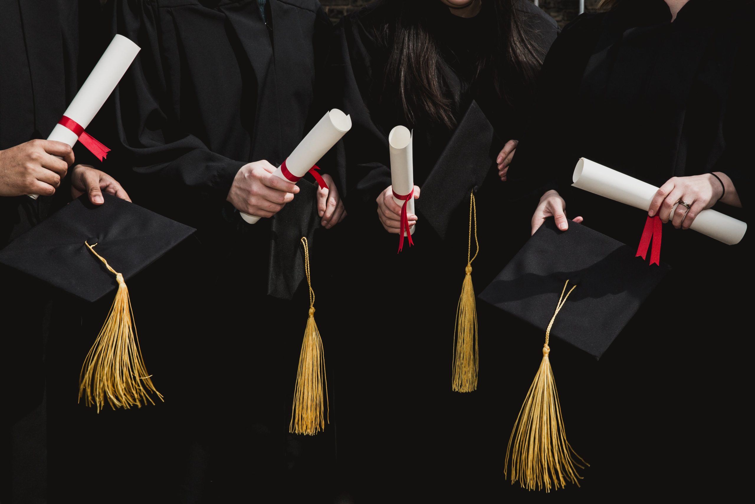four-grad-students-caps-and-diplomas